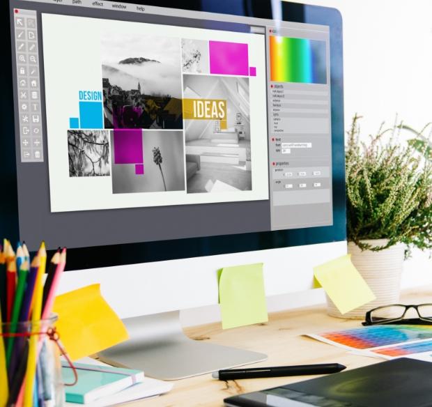 A web & app designer’s desk with a moodboard being shown on the computer monitor.